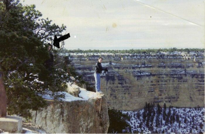 Persona en acantilado con paisaje nevado y figura misteriosa detrás de árbol en foto real sin explicación hasta hoy