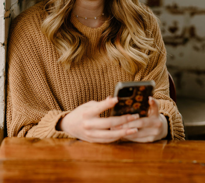 Mujer usando teléfono móvil con funda floral, mostrando cómo los teléfonos ayudan a descubrir verdades ocultas. Mujer usando teléfono móvil con funda floral, mostrando cómo los teléfonos ayudan a descubrir verdades ocultas.