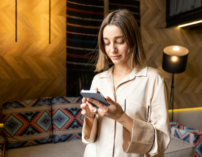 Mujer usando teléfono móvil en sala moderna, ejemplificando cómo los teléfonos ayudan a descubrir verdades ocultas. Mujer usando teléfono móvil en sala moderna, ejemplificando cómo los teléfonos ayudan a descubrir verdades ocultas.