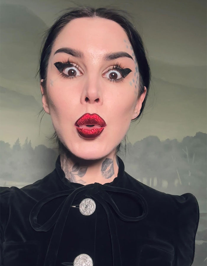 Kat Von D con maquillaje llamativo y tatuajes visibles en el rostro y cuello mostrando su transformación espectacular.
