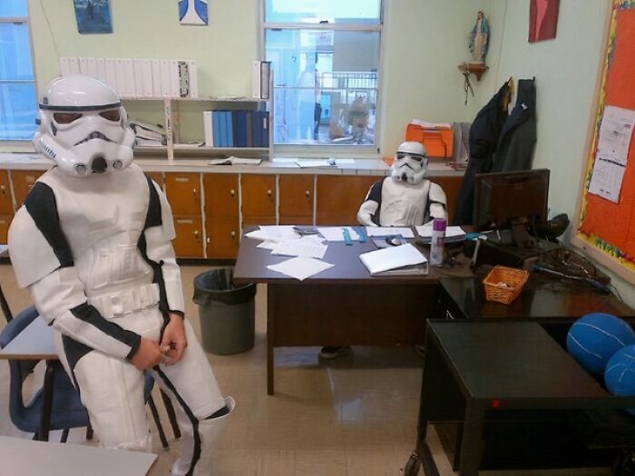 Dos personas con uniformes graciosos de stormtroopers dentro de una oficina haciendo que dudan del diseño de uniformes.