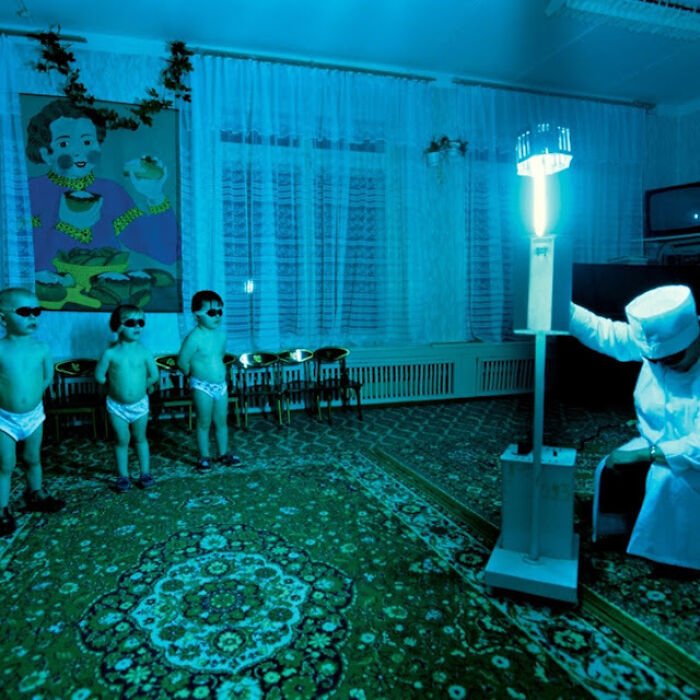 Niños en pañales con gafas oscuras bajo luz ultravioleta en habitación oscura en una escena real aterradoramente inquietante. Niños en pañales con gafas oscuras bajo luz ultravioleta en habitación oscura en una escena real aterradoramente inquietante.