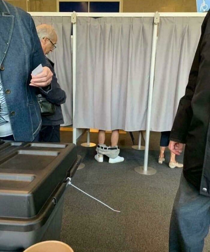 Persona con pantalones bajados dentro de un cubículo raro, imagen extraña que se ha vuelto peculiar y maldita a la vez.