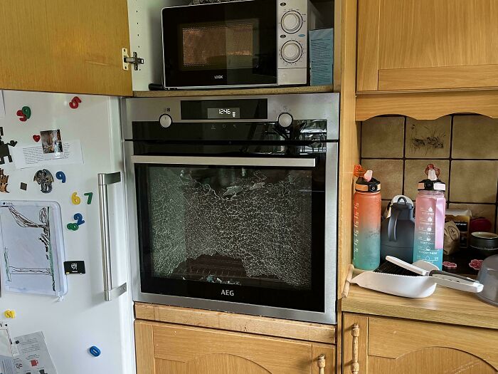 Horno con puerta de vidrio rota en cocina, ejemplo de fotos de vacaciones que no salieron como se esperaba.
