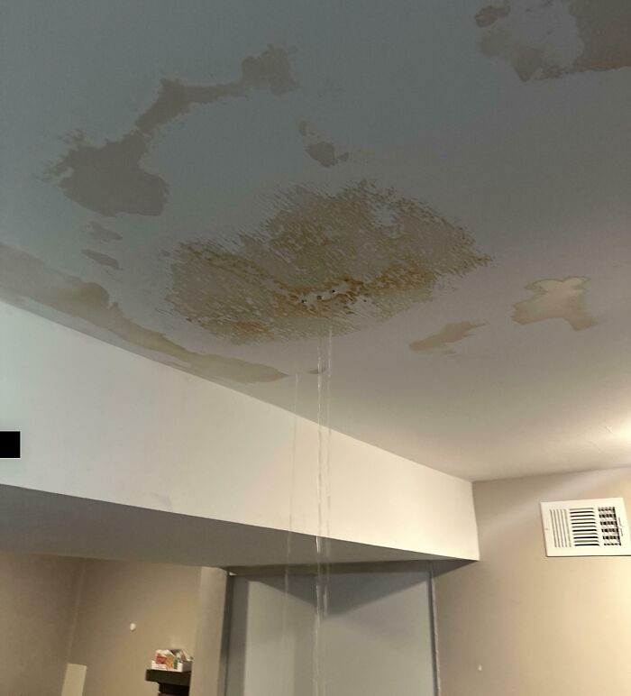 Techo de habitación con manchas de humedad y agua filtrándose durante las vacaciones, una foto de vacaciones que no salió como se esperaba.