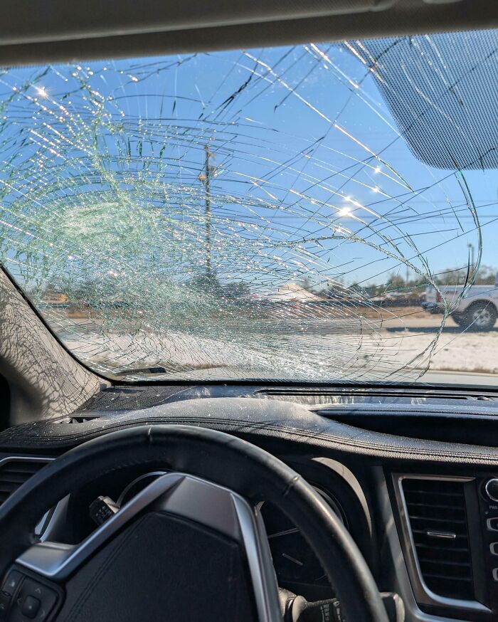 Interior de un coche con el parabrisas roto capturado en fotos de vacaciones que no salieron como se esperaba.
