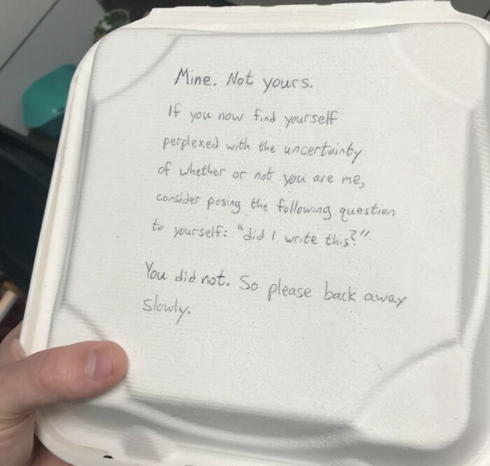 Nota pasivo-agresiva escrita a mano en tapa de contenedor de comida para llevar, con mensaje de advertencia personal en el trabajo.
