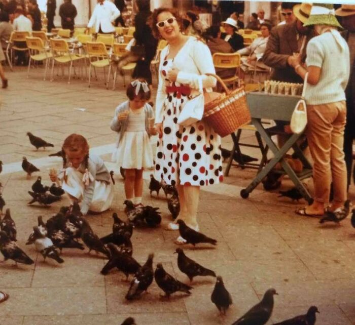 Mujer y niñas alimentando palomas en plaza, disfrutando de un momento divertido durante un tiempo diferente. Mujer y niñas alimentando palomas en plaza, disfrutando de un momento divertido durante un tiempo diferente.