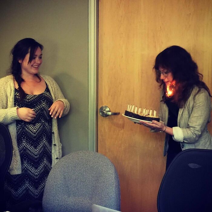 Mujer con pastel de cumpleaños en llamas justo antes de un desastre divertido capturado en foto hilarante.