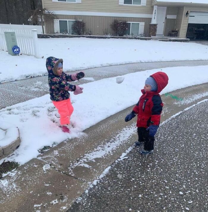 Niños jugando en la nieve segundos antes de una caída, capturando un momento divertido lleno de anticipación y desastre inminente.