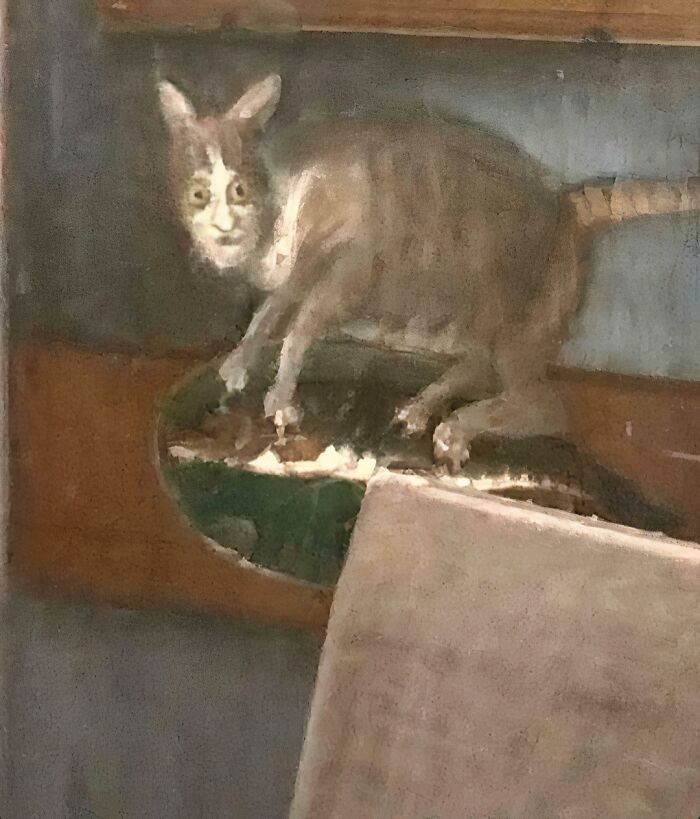 Gato medieval con rostro humano en pintura antigua, destacando la parte inferior del cáliz de comida para gatos.