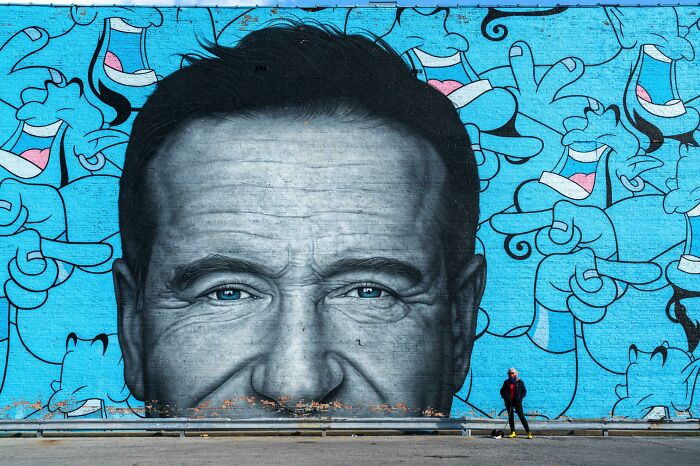 Gran mural urbano con rostro humano en escala enorme, reflejando el tamaño real explicado por el cuerpo humano.