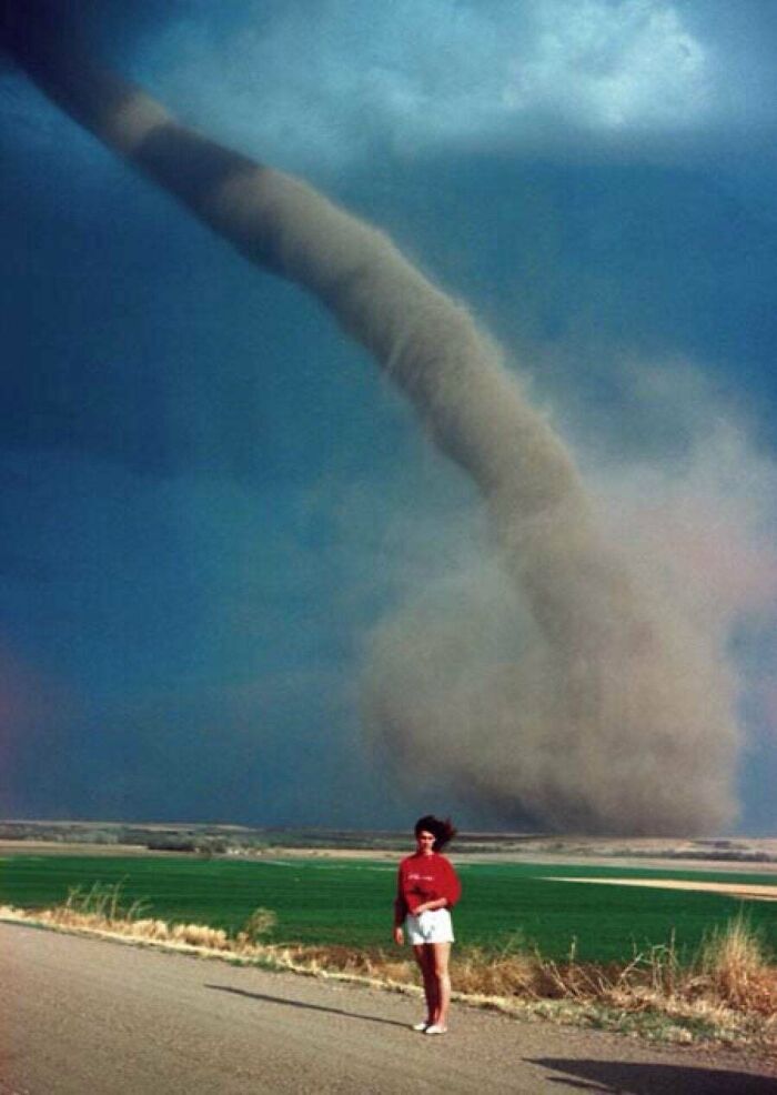 Persona en carretera mostrando el tamaño real de un tornado en una imagen fascinante del cuerpo humano y la escala natural.
