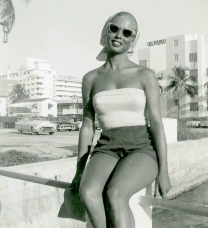 Mujer vintage con gafas de sol y ropa retro disfrutando en un entorno urbano de una época diferente. Mujer vintage con gafas de sol y ropa retro disfrutando en un entorno urbano de una época diferente.