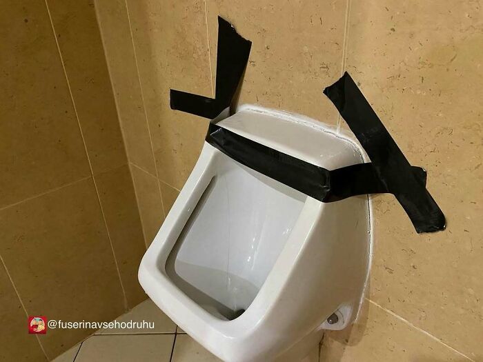 Orinal con cinta negra mal colocado, un divertido fallo de construcción que provoca risa y sorpresa.