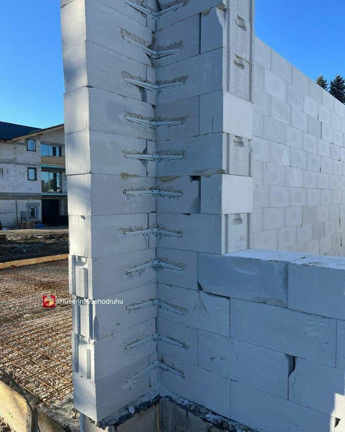 Pared de construcción con fallos divertidos, bloques mal colocados y errores visibles en obra en proceso.