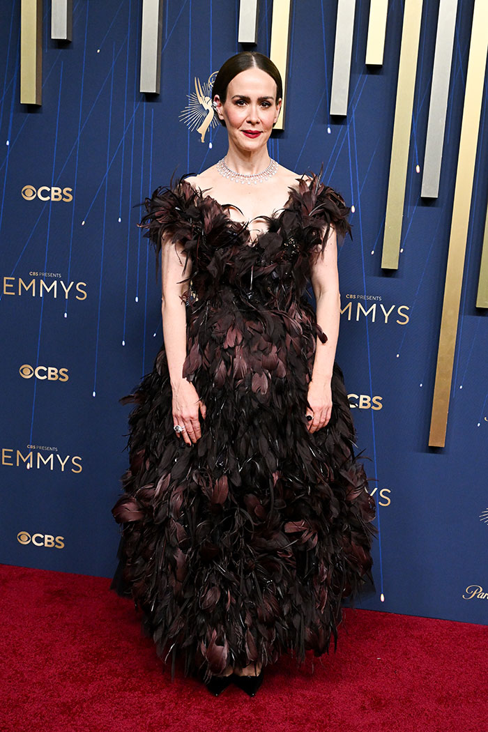Mujer con vestido negro de plumas en la alfombra roja, entre los mejores y peores looks de moda en los Emmys 2025
