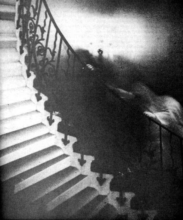 Foto antigua en blanco y negro de una figura fantasmal en una escalera, imagen real inexplicable hasta hoy.
