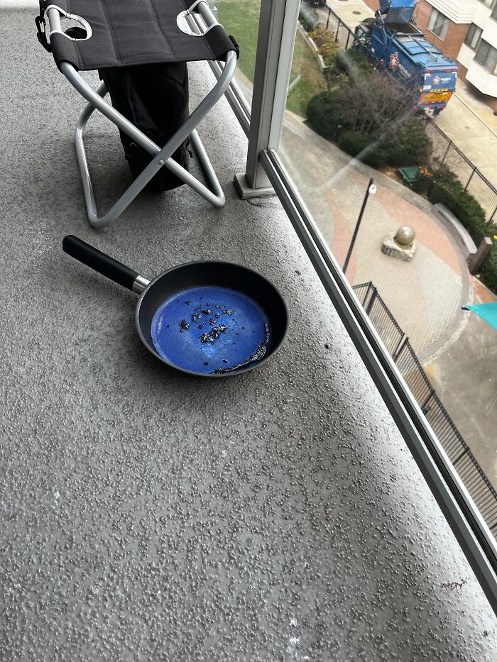 Sartén quemada olvidada en balcón al aire libre, mostrando un ejemplo peligroso sin darse cuenta del riesgo.