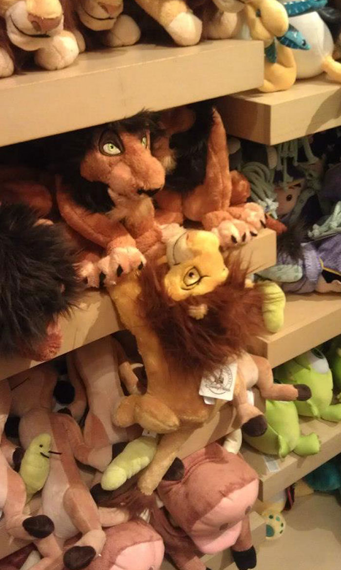 Peluches de leones en parque de diversiones, capturando momentos divertidos con gran sentido del humor.