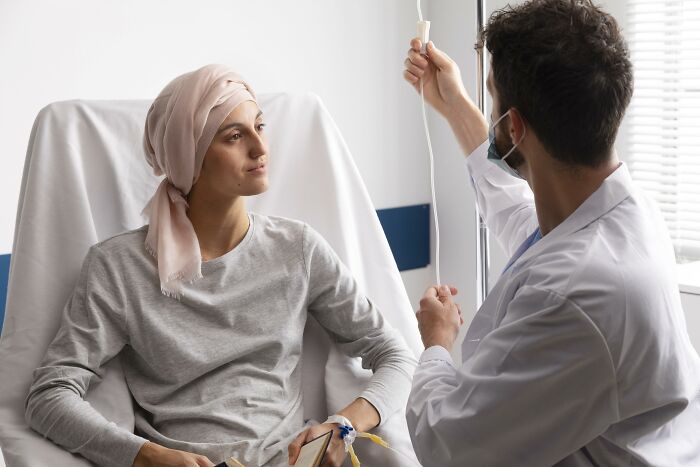 Paciente con pañuelo en hospital cuidada por doctor, imagen relacionada con historias de horror de médicos y enfermeras.