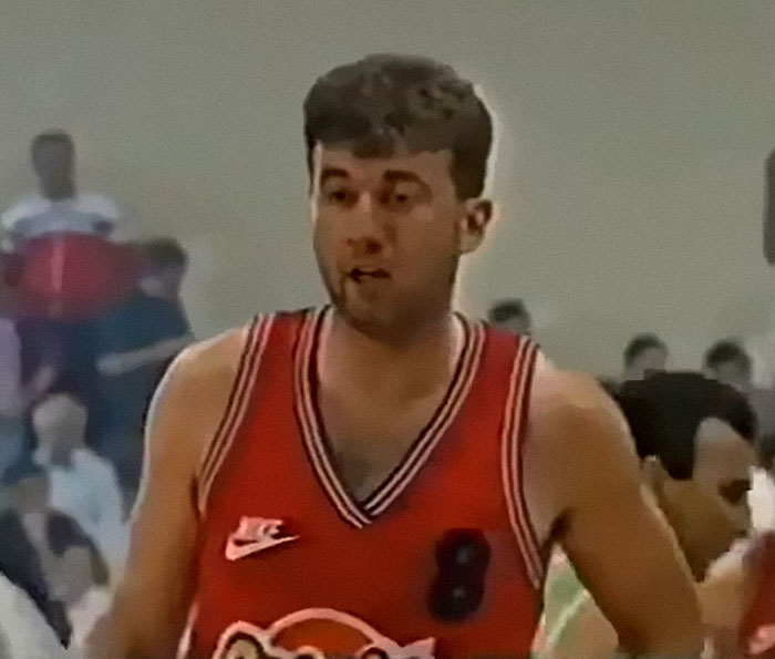 Jugador de baloncesto con camiseta roja en partido, representando decisiones tan malas que arruinaron vidas.