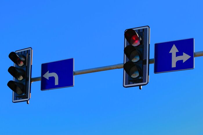 Semáforos en rojo con señales de dirección, representando un accidente que cambió el mundo de alguien.