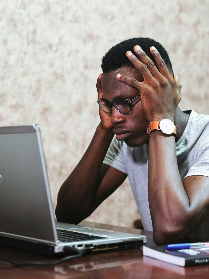 Hombre preocupado frente a laptop, representando a alguien cuya vida se derrumbó accidentalmente por otra persona.