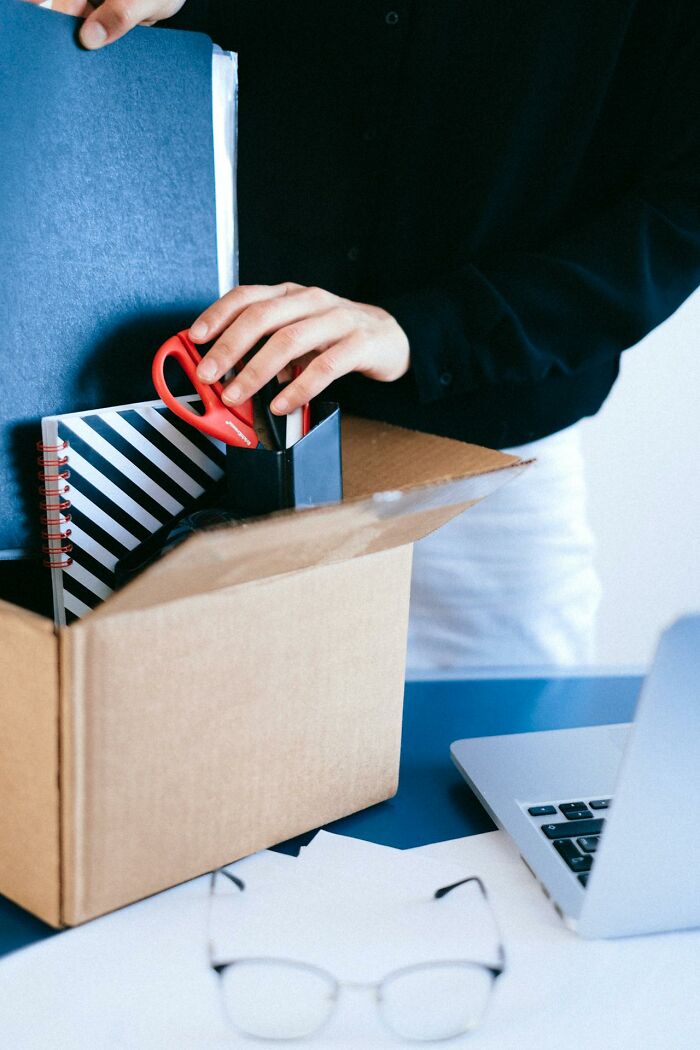Persona empacando en caja de cartón, simbolizando el impacto accidental que puede causar que el mundo de alguien se desmorone.