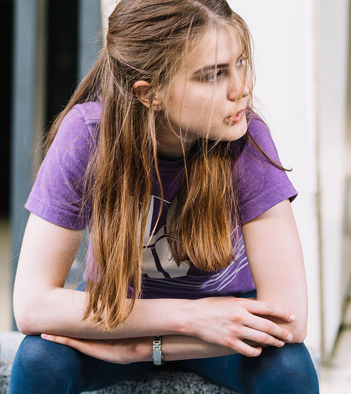 Joven pensativa con camiseta morada sentada, evocando historias reales que asustan en Nutty Putty Cave. Joven pensativa con camiseta morada sentada, evocando historias reales que asustan en Nutty Putty Cave.