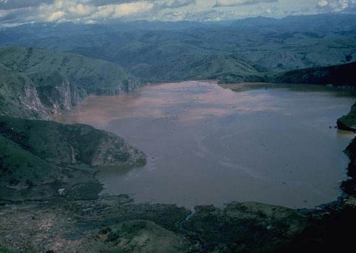 Laguna rodeada de montañas bajo cielo nublado, con ambiente misterioso que recuerda a Nutty Putty Cave. Laguna rodeada de montañas bajo cielo nublado, con ambiente misterioso que recuerda a Nutty Putty Cave.