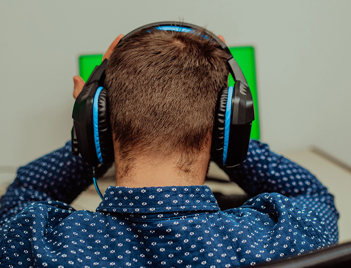 Persona con auriculares grandes en una habitación frente a una pantalla verde, representando historias de Nutty Putty Cave. Persona con auriculares grandes en una habitación frente a una pantalla verde, representando historias de Nutty Putty Cave.