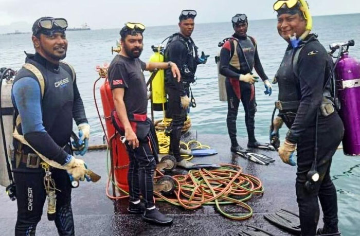 Grupo de buzos preparados para explorar Nutty Putty Cave con equipo completo en un muelle junto al mar. Grupo de buzos preparados para explorar Nutty Putty Cave con equipo completo en un muelle junto al mar.