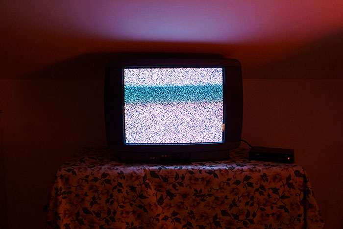 Televisor antiguo mostrando estática en un cuarto oscuro, creando una atmósfera inquietante relacionada con Nutty Putty Cave. Televisor antiguo mostrando estática en un cuarto oscuro, creando una atmósfera inquietante relacionada con Nutty Putty Cave.
