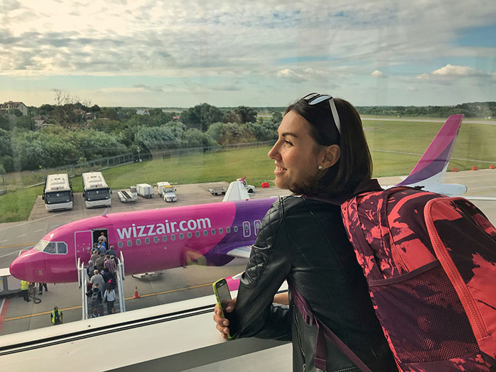 Mujer con mochila mirando aviones, ilustrando consecuencias que las mentiras tuvieron para otras personas.
