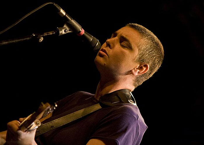 Cantante y guitarrista actuando en vivo, destacando en discusión sobre celebridades que se niegan a jugar baloncesto en silla de ruedas. Cantante y guitarrista actuando en vivo, destacando en discusión sobre celebridades que se niegan a jugar baloncesto en silla de ruedas.