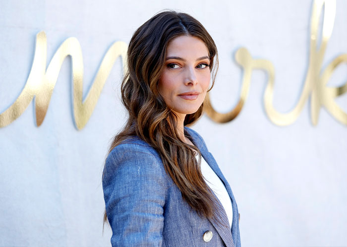 Mujer famosa con expresión serena, mostrando los costos ocultos de la fama en un evento al aire libre.