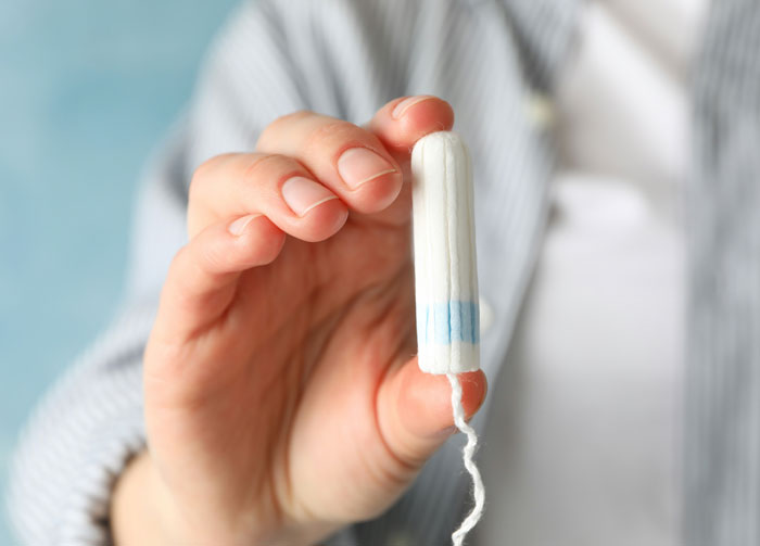 Mano sosteniendo tampón blanco con azul ilustrando desconocimiento común en situaciones hilarantes y sorprendentes.