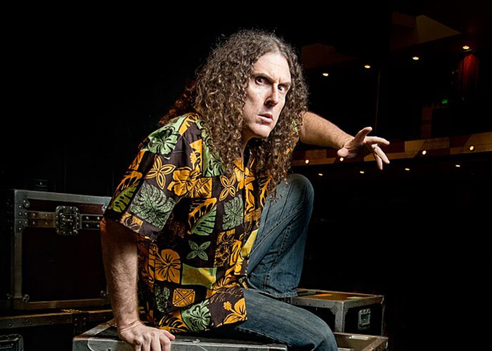 Hombre con camisa hawaiana en escenario oscuro, reflejando controversias y actitudes de celebridades expuestas. Hombre con camisa hawaiana en escenario oscuro, reflejando controversias y actitudes de celebridades expuestas.