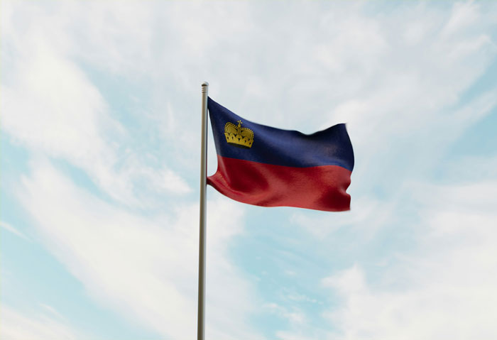 Bandera ondeando al viento bajo cielo azul, ilustrando momentos divertidos de personas ignorando conocimientos comunes.