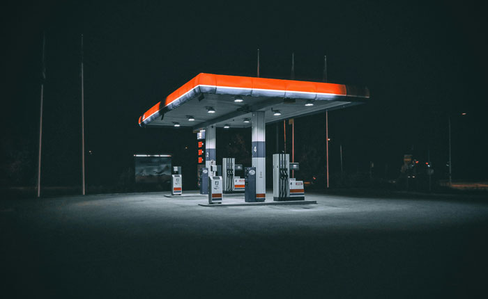 Gasolinera vacía iluminada en la noche, ilustrando momentos hilarantes de personas con desconocimiento común impactante.