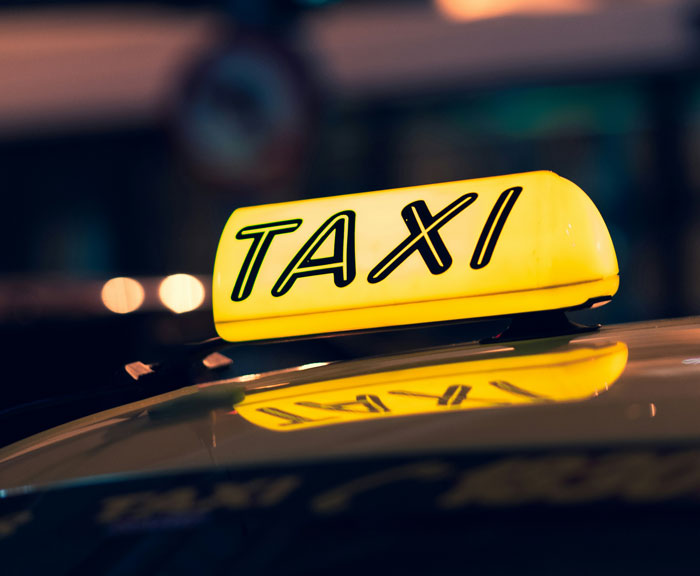 Señal luminosa de taxi amarillo por la noche, representando lugares malos que la gente ha visitado según opiniones.