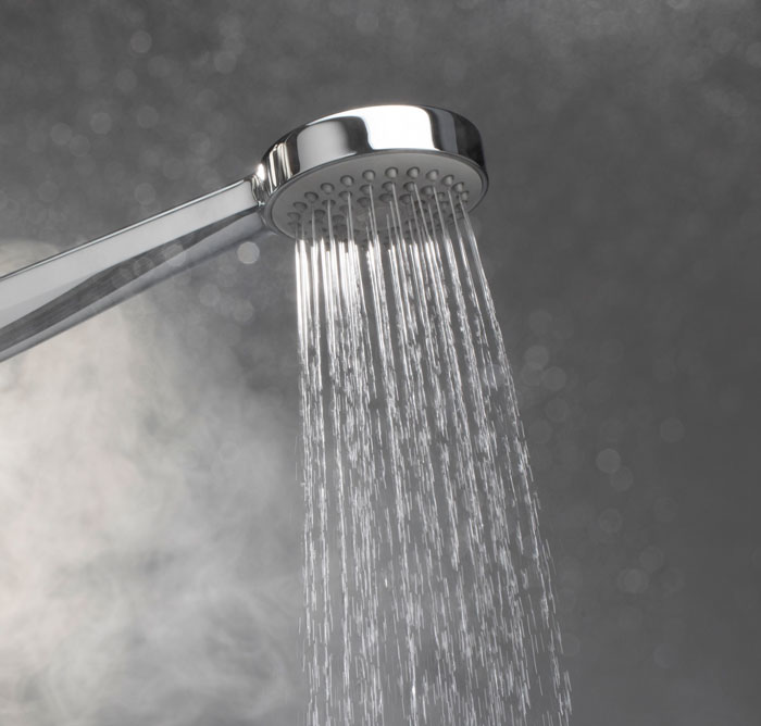 Ducha de agua caliente con vapor, simbolizando momentos inesperados y situaciones incómodas en el trabajo.