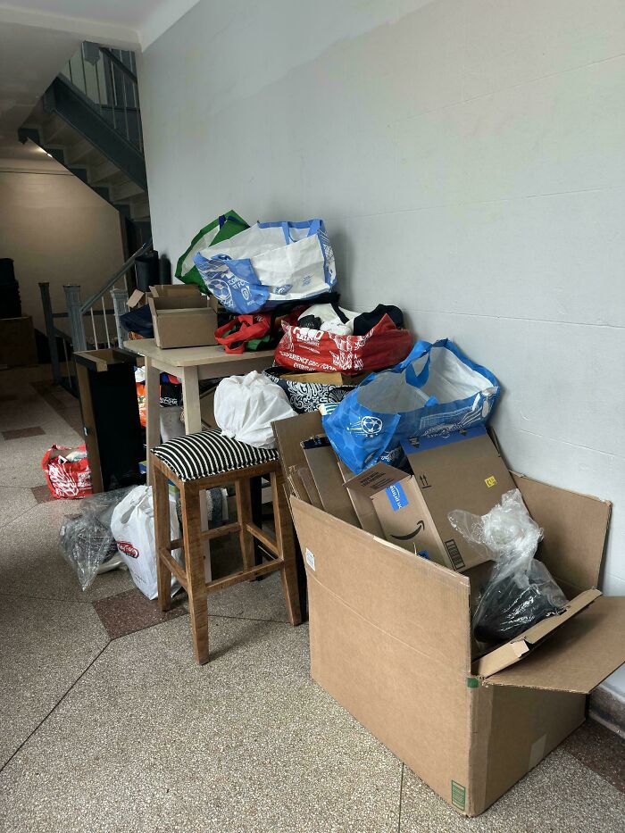 Montones de basura y cajas acumuladas en pasillo, mostrando un claro ejemplo de personas expuestas por su mal comportamiento.