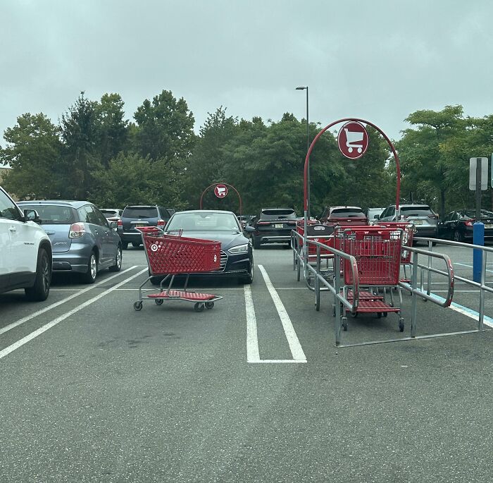 Carro de supermercado bloqueando dos espacios de estacionamiento, ejemplo de personas expuestas por comportamiento irrespetuoso.