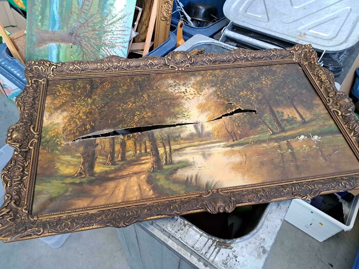 Cuadro antiguo con paisaje dañado por un gran corte, representando pequeñas molestias muy irritantes visuales.