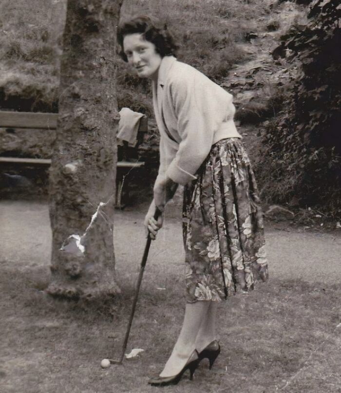 Mujer jugando golf con tacones en una foto vintage, mostrando un momento divertido de otra época. Mujer jugando golf con tacones en una foto vintage, mostrando un momento divertido de otra época.
