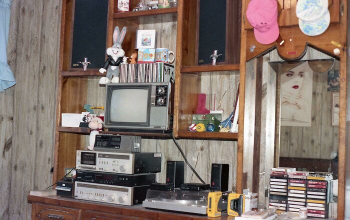 Equipo de música y televisión vintage en habitación con decoración clásica que refleja el estilo de los años 80 wild.