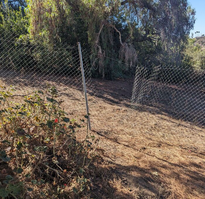 Valla metálica mala instalada, mostrando una de las 50 molestias leves pero muy molestas en el jardín.