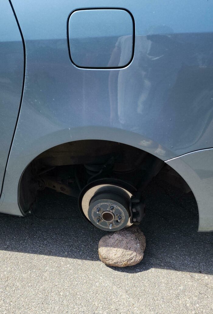 Freno de disco de auto sin rueda apoyado en una piedra, ejemplo de inconvenientes leves pero muy frustrantes.